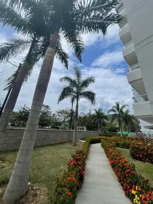 a sidewalk with flowers and palm trees in a park at Luxury Apartment Citadela de Sole Santa fe de Antioquia in Santa Fe de Antioquia