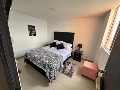 a bedroom with a bed with a black and white comforter at Apartamento Medellin con Jacuzzi privado in Medellín