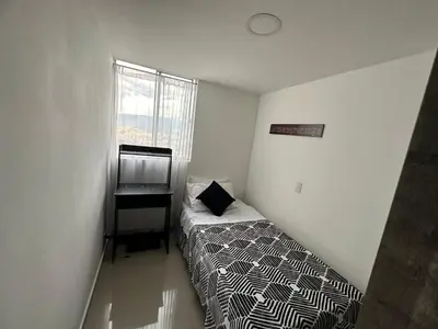 a small bedroom with a bed and a desk at Apartamento Medellin con Jacuzzi privado in Medellín