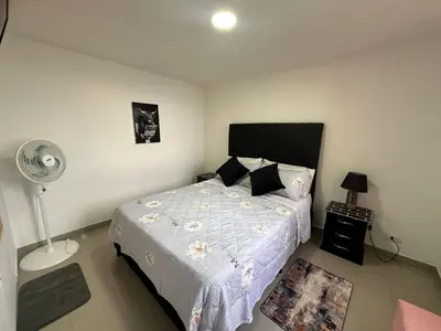 a bedroom with a bed and a fan at Apartamento Medellin con Jacuzzi privado in Medellín