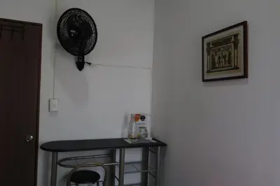 a room with a table and a fan on the wall at Living Poblado Manila 301 E Habitación Doble in Medellín