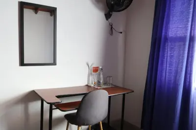 a table and a chair in a room with blue curtains at Living Poblado Manila 301 E Habitación Doble in Medellín
