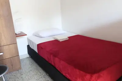 a bedroom with a bed with a red blanket at Living Poblado Manila 301 E Habitación Doble in Medellín