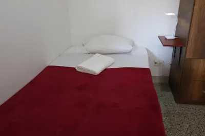 a bed with a red and white blanket on it at Living Poblado Manila 301 F Habitación Individual in Medellín