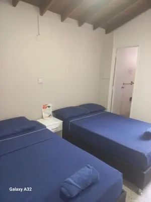 two beds with blue sheets in a room at Living Poblado Manila 301 G Hab Doble con Baño in Medellín