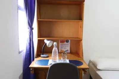a desk with a bottle and a lamp on it at Living Poblado Manila 301 B Habitación Individual in Medellín