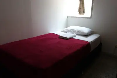 a bed with a red and white blanket and a window at Living Poblado Manila 301 C Habitación Individual in Medellín