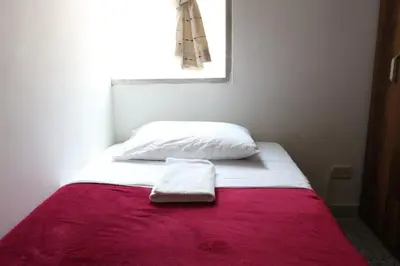 a bed with a red blanket and a white pillow at Living Poblado Manila 301 C Habitación Individual in Medellín