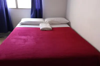 a bed with a red blanket on top of it at Living Poblado Manila 301 C Habitación Individual in Medellín
