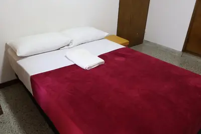a bed with a red and white blanket on it at Living Poblado Manila 301 C Habitación Individual in Medellín