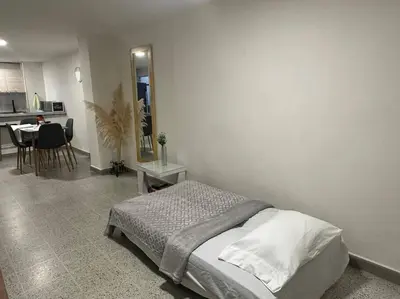 a bedroom with a bed and a dining room at Apartamento nuevo Laureles-Estadio 900 mbps wifi barrio tranquilo cerca a la 70 in Medellín