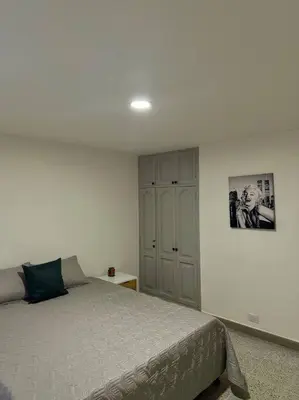 a bedroom with a bed and a cabinet in it at Apartamento nuevo Laureles-Estadio 900 mbps wifi barrio tranquilo cerca a la 70 in Medellín