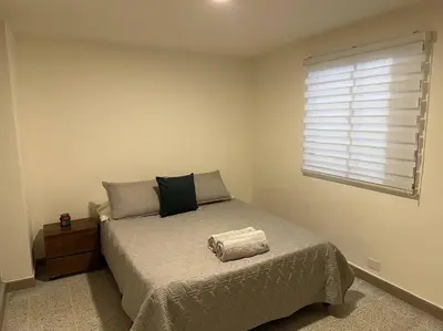 a bedroom with a large bed with a window at Apartamento nuevo Laureles-Estadio 900 mbps wifi barrio tranquilo cerca a la 70 in Medellín