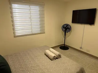 a bedroom with a bed and a fan and a window at Apartamento nuevo Laureles-Estadio 900 mbps wifi barrio tranquilo cerca a la 70 in Medellín