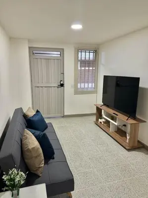 a living room with a couch and a flat screen tv at Apartamento nuevo Laureles-Estadio 900 mbps wifi barrio tranquilo cerca a la 70 in Medellín