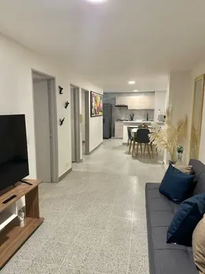 a living room with a couch and a tv at Apartamento nuevo Laureles-Estadio 900 mbps wifi barrio tranquilo cerca a la 70 in Medellín