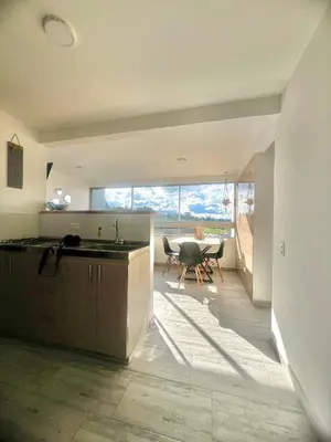 a kitchen with a table and a dining room at Apartamento familiar y de descanso in Rionegro