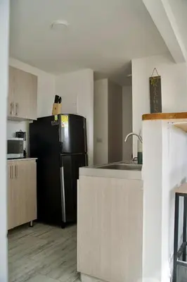 a kitchen with a black refrigerator and a sink at Apartamento familiar y de descanso in Rionegro