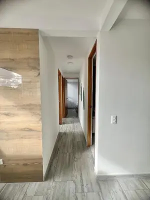 a hallway with white walls and wooden floors at Apartamento familiar y de descanso in Rionegro
