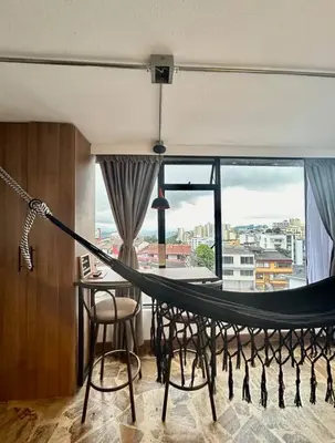 a hammock in a room with a large window at Open Sky in Manizales