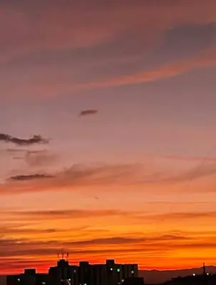 a city skyline at sunset with a kite in the sky at Open Sky in Manizales