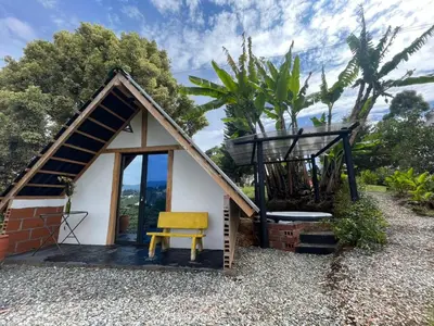 a small house with a yellow chair and a balcony at Encanto Verde in Rionegro
