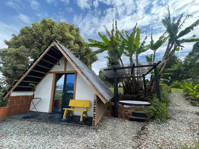 a small house with a yellow chair and a bench at Encanto Verde in Rionegro