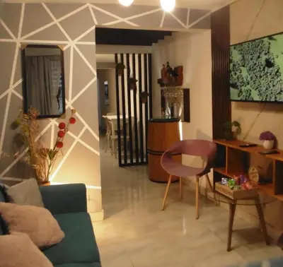 a living room with a couch and a table and a chair at Hospedaje J&L in Medellín