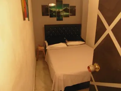 a small room with two beds and a door at Hospedaje J&L in Medellín