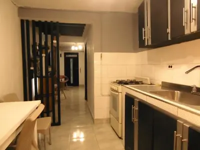 a kitchen with a sink and a stove top oven at Hospedaje J&L in Medellín