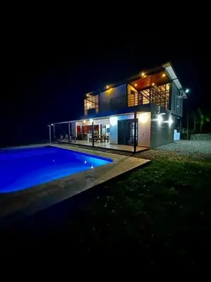 a house with a swimming pool at night at Finca cerca a Medellín Villa Cerat in Sopetran