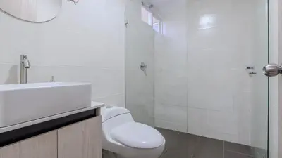 a white bathroom with a toilet and a sink at Apartamento en Laureles con piscina y parquedero 802 in Medellín