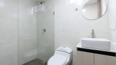 a white bathroom with a toilet and a sink at Apartamento en Laureles con piscina y parquedero 802 in Medellín