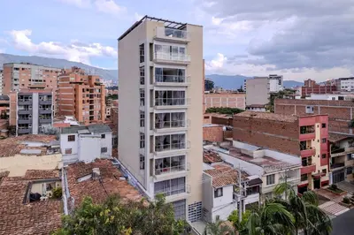 a tall white building in a city with buildings at Apartamento en Laureles con piscina y parquedero 802 in Medellín