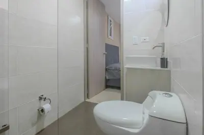a white bathroom with a toilet and a sink at Apartamento en Laureles 2BR con rooftop y piscina 702 in Medellín