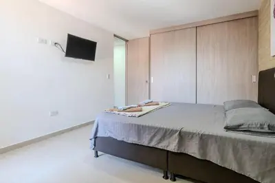 a bedroom with a bed with a tv on it at Apartamento en Laureles 2BR con rooftop y piscina 702 in Medellín