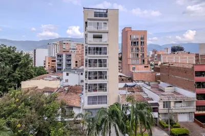 a tall white building in a city with buildings at Apartamento en Laureles 2BR con rooftop y piscina 702 in Medellín