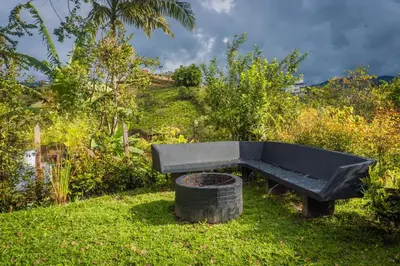 a black bench sitting in the grass next to a trash can at Cabaña333 in Guatapé
