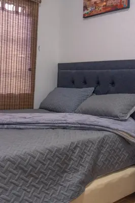 a bed with a blue comforter in a bedroom at Cabaña333 in Guatapé