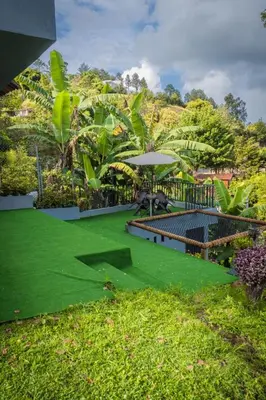 a green lawn with a table and an umbrella at Cabaña333 in Guatapé