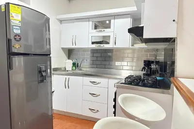 a kitchen with white cabinets and a stainless steel refrigerator at HOSPEDAJE LAURa in Medellín