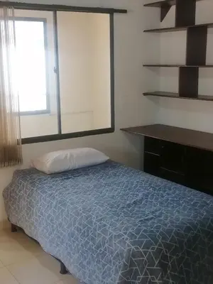 a bedroom with a blue bed and a window at Cuarto con cuarto de baño y terraza in Medellín