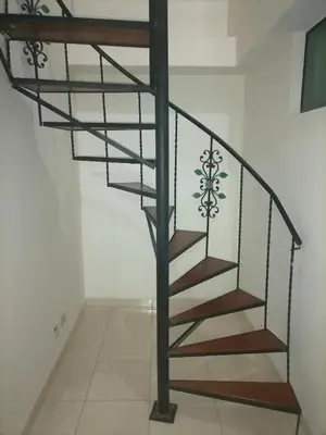 a metal spiral staircase in a white room at Cuarto con cuarto de baño y terraza in Medellín
