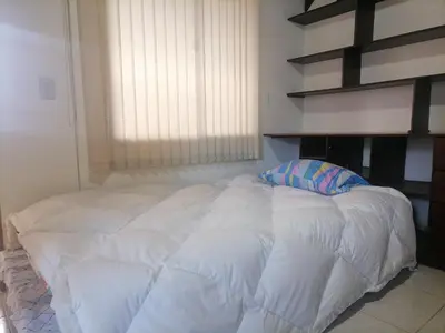 a large white bed in a room with a window at Cuarto con cuarto de baño y terraza in Medellín