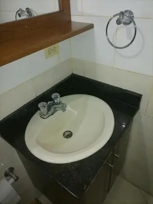 a white sink in a bathroom with a black counter at Cuarto con cuarto de baño y terraza in Medellín