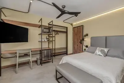 a bedroom with a bed and a flat screen tv at Nutibara Express By HOUSY in Medellín