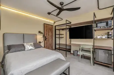 a bedroom with a bed and a flat screen tv at Nutibara Express By HOUSY in Medellín