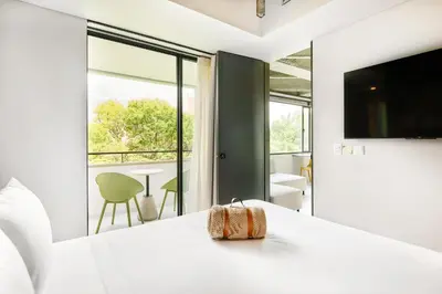 a bedroom with a white bed and a large window at Firenze Lofts in Medellín