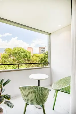 a room with a table and chairs and a large window at Firenze Lofts in Medellín