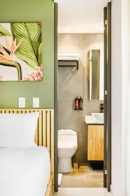 a bathroom with a bed and a toilet and a sink at Firenze Lofts in Medellín